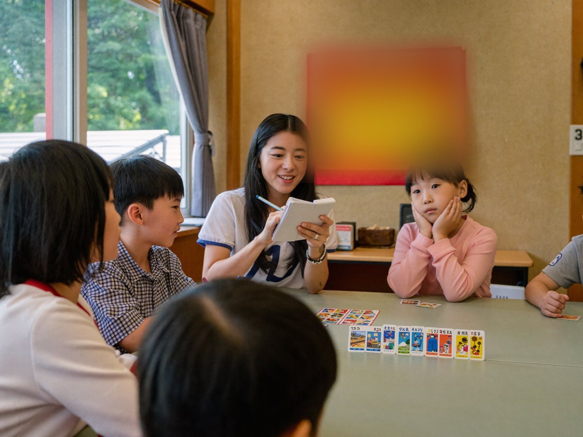 ワークショップを見学しながらメモを取る教員